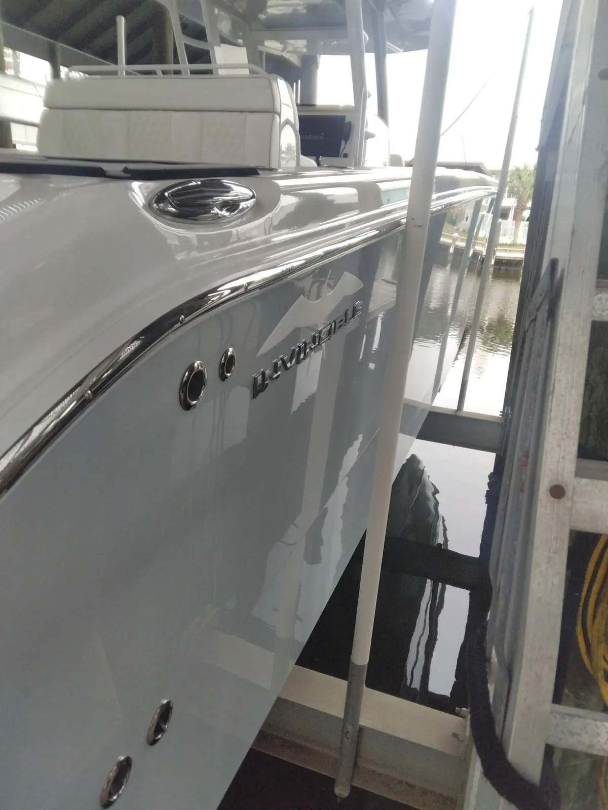 Restored glossy white boat side beside a dock