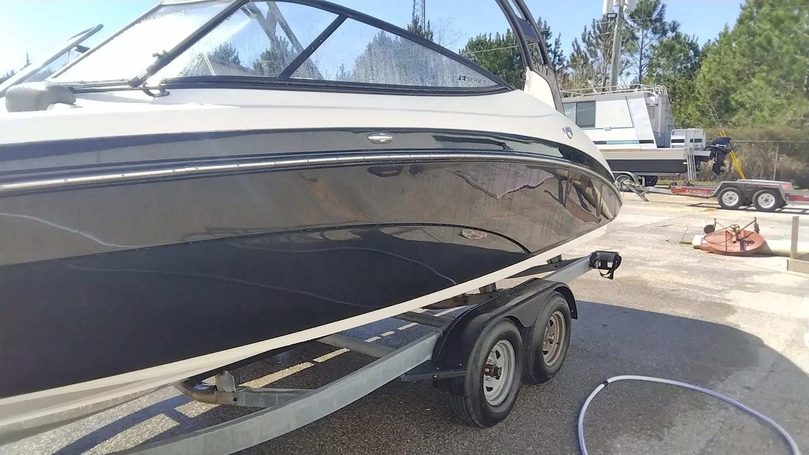 Polished black and white boat on a trailer outdoors