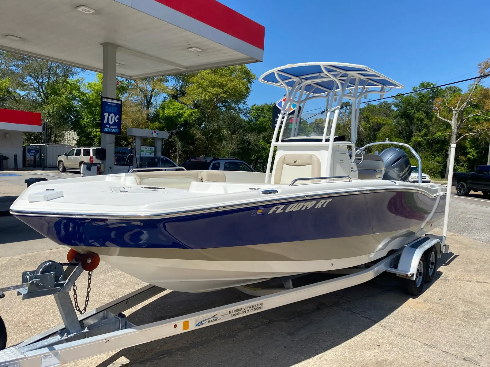 Polished blue and white center-console boat on a trailer
